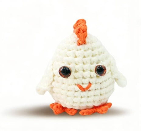 Handmade chubby white chicken crochet stuffed animal. A kawaii, round amigurumi plushie featuring a cute orange comb and little feet, perfect as a desk pet or a finished handmade gift