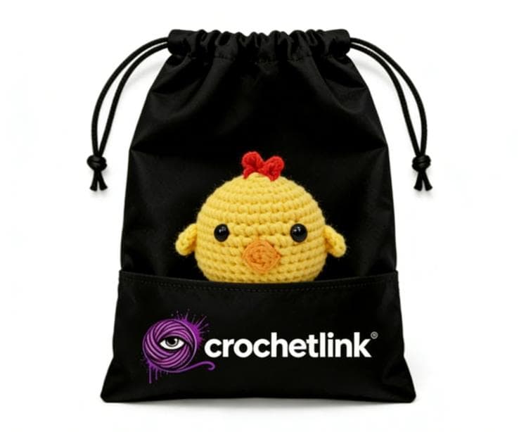 A kawaii, round yellow amigurumi baby chick crochet plushie hatched from a white eggshell bottom, isolated on a clean white background.