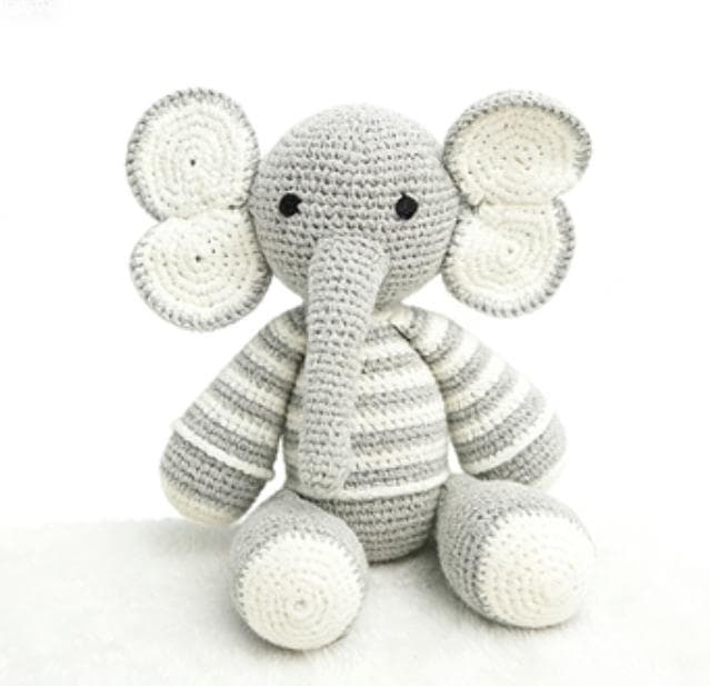 Handmade cute grey and white elephant crochet stuffed animal. A kawaii amigurumi plushie featuring a striped body, large floppy ears, and a long trunk, perfect as neutral nursery decor, a desk pet, or a finished handmade gift.